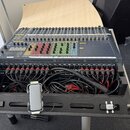 Míchací pult v černé barvě s barevnými posuvníky (červené, zelené, žluté) a řadou knoflíků. Na přední straně je viditelný nápis SOUNDCRAFT a označení…