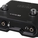 Černý zvukový interface s nápisem UX1 a logem LINE 6. Zařízení má dva kovové ovratidla s popisky MIC GAIN a OUTPUT, vstup pro mikrofon (MIC), instrum…