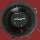 Spodní strana elektronického bubnu v černé barvě. Uprostřed je bílé logo Roland a nad ním nápis PD-140DS V-PAD DIGITAL SNARE. Dole je vidět sériové č…