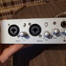 Stříbrný audio rozhraní s dvěma kombinovanými konektory XLR/jack. Na panelu jsou nápisy Mic/Inst 1, Gain (Min Max), +48V, Mic/Inst 2, Gain (Min Max),…