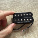 Černý humbucker s kovovými póly. Na spodním snímači je bílý nápis Seymour Duncan. Z nástroje vedou čtyři barevné vodiče (černý, bílý, červený a zelen…