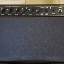 Černý basový kombo zesilovač s texturovaným povrchem. Na ovládacím panelu jsou nápisy INPUT, ACTIVE EQUALIZER, OUTPUT, PATCH BAY a POWER, dále označe…