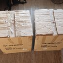 Dvě hnědé kartonové krabice s viditelným opotřebením a pomačkanými vrchy. Na přední straně obou krabic je černý nápis M-AUDIO a text MADE IN CHINA. N…