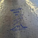 Detail kovového činely s viditelným broušením a drobnými povrchovými nečistotami. Na povrchu je modrý nápis MELLOW RIDE 20" a pod ním logo s textem B…