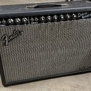 Kytarový zesilovač s černým povrchem a šedou síťovkou. Na přední straně je bílé logo Fender a v pravém dolním rohu nápis Tone Master. V horní části s…