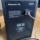 Zadní strana černého aktivního monitorovacího reproduktoru. Na horní části je bílý nápis Pioneer DJ a označení RIGHT, ve středu je vstup INPUT. Ve sp…