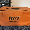 Pomůcka v podobě oranžového přepravního sáčku s černým rukojetí a lemováním. Na přední straně je černý nápis HOT® a pod ním text true tube amplifiers…