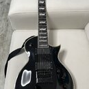 Černá elektrická kytara s bílým lemováním hran těla. Na hlavě je viditelné logo Ltd a nápis ESP. Kytara má dva humbuckery, tři ovládací knoflíky a je…
