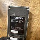 Fotografie zachycuje spodní stranu šedého efektpedálu s černým základním panelem. Na štítku je viditelné logo BOSS a nápisy CAN ICES-003(B)/NMB-003(B…