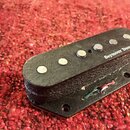 Černý humbucker s šesti viditelnými póly. Na povrchu je bílý nápis Seymour Duncan. Nástroj vykazuje známky opotřebení v podobě odřesů a nečistot na p…