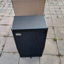 Černý basový reproduktor v hranatém provedení s texturovaným povrchem a přední mřížkou. V horní části je viditelné logo DV MARK. Nástroj stojí na dla…
