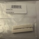Dvě bílé kostěné matky na struny v plastovém sáčku. Vedle nich je papírový štítek s čárcovým kódem a nápisy „String Nut, Bone“ a „101757:001:002:009“…