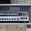 Kytarový zesilovač v transportním case s nápisem GALLIEN-KRUEGER. Na předním panelu jsou ovládací knofíky, přepínače a konektory s označením 700RB MA…