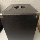 Černý reproduktorový box potažený texturovaným vinylem s kovovými rohovými chrániči. Na horní straně je umístěna úchytná rukojeť s nápisem BOE. Povrc…