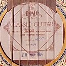 Detail rozetky akustické kytary s vloženým štítkem. Na štítku je uveden nápis AMADA, CLASSIC GUITAR a text MADE BY Strunal MANUFACTURE LUBY - CZECH R…