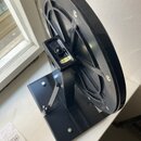 Černý kovový trenažér s velkým plastovým setrvačníkem. Na bočním držáku je viditelný žlutý štítek s nápisem MADE IN TAIWAN. Podstavec je tvořen černý…