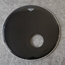 Černá bubnová blána s vyříznutým otvorem v dolní části. V horní části je bílé logo REMO a pod ním menší nečitelný nápis. Povrch je hladký a lesklý be…