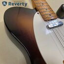 Detail horní části těla elektrické kytary s bílým pickguardem a hnědým gradientním lakem (sunburst). Viditelný je dřevěný hриф s javorovou hmatnicí a…