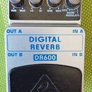 Stříbrný efektový pedál s nápisem DIGITAL REVERB a označením DR600. Na horní části jsou čtyři ovládací knoflíky s popisky LEVEL, TONE, TIME a MODE (s…