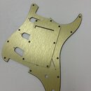 Zlatý kovový pickguard pro elektrickou kytaru s broušeným povrchem. Má výřezy pro snímače a ovládací prvky. Na komponentu nejsou viditelné žádné znač…