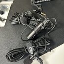 Černý lavalier mikrofon s kabelagem a malou černé větřivkou na koncích. Na těle mikrofonu je bílý nápis SYNC a pod ním menší text Lav-USB. Součástí j…