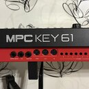 Zadní strana klaviatury v černo-červeném provedení. Na černém horním panelu jsou bílé nápisy AKAI PROFESSIONAL a MPC KEY 61. Na červeném spodním pane…