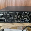 Zadní strana černého zesilovače s ovládacími prvky a konektory. Jsou zde nápisy POST, PRE, EFFECTS (FX ON, BYPASS, RETURN, SEND), LEVEL, SLAVE a OUT,…