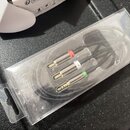 V průhledném plastovém obalu je černý kabel s třemi konektory typu jack. Konektory jsou rozbarvené červeným, bílým a zeleným kroužkem. Na kabelu je v…