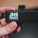 Černý kytarový efekt v kovovém šasi s texturou. Na přední straně je bílý nápis JHS PEDALS a pod ním menší text LITTLE BLACK AMP BOX. Na horní straně…