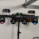 Černý světelný systém GigBAR MOVE na stativu. Horní lišta nese dva malé reflektory a centrální ovládací jednotku s nápisem GigBAR MOVE. V dolní části…