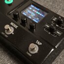 Černý kytarový efekt s displejem, na kterém je viditelný nápis B2A Turn SC a Kinky Comp s parametry Sens, Mix a Attack. Zařízení má několik otočných…