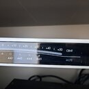 Detailní záběr na digitální ladicí displej s kovovým rámem. Na horní stupnici jsou bílé nápisy -10, 0, +10, +20, +30, +40, +50 a CENT. Pod nimi jsou…