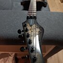 Elektrická kytara s tmavým tělem a hnedým hmatníkem. Na hlavě nástroje je nápis C-8 FR PRO a logo Ibanez s přívětkem Premium. Povrch hlavy vykazuje z…