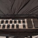 Stříbrný MIDI pedál v černé přepravní tašce. Na zařízení je nápis FCB1010 MIDI FOOT CONTROLLER a řada čierných spínacích tlačítek s číslováním 1 až 8…