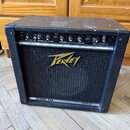 Černý kytarový kombo zesilovač s látkovou přední síťovkou. Na mřížce je žluté logo Peavey a v dolní části nápis BLAZER 158. Horní ovládací panel obsa…