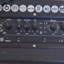 Detail ovládacího panelu černého kytarového komba. Na panelu jsou nápisy STEREO 10 V2 a ID:CORE, ovládací prvky VOICE, GAIN, VOLUME, EQ a sekce EFFEC…
