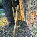 Fotografie zachycuje zadní stranu hlavy kytary z přírodního světlého dřeva. Na hlavě jsou vidět kovové ladičky. Povrch dřeva vykazuje drobné známky o…
