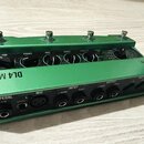 Zelený kytarový efekt s nápisy LINE 6 a DL4 MKII. Na horní straně jsou čtyři stoupavé spínače a řada otočných potenciometrů s popisky MIX, TWEEZ, EAK…