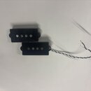 Dvě černé kytarové snímače typu humbucker s čtyřmi viditelnými póly. Jeden ze snímačů má připojený stříbrný pletený kabel s odkrytými konci. Na sníma…