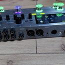 Stříbrný kytarový procesor Mooer GE300 s displejem a podsvícenými spínači. Na přední straně jsou viditelné nápisy GE300 a MOOER. Zadní panel obsahuje…