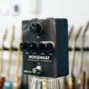 Kytarový efekt v černé kovové krabičce s vlnitým vzorem na horní straně. Na přední straně jsou pětky černé otočné knoflíky s nápisy GAIN, LEVEL, VOIC…