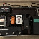 V hliníkovém kufru je pedalboard s několika efekty a napájecím zdrojem Voodoo Lab PEDAL POWER ISO 5. Jsou zde pedály Boss TU-2 Chromatic Tuner, MXR p…