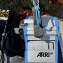 Modrý a stříbrný reflektor s černými plastovými prvky. Na spodní části je bílý štítek s technickými údaji a nápisy „MADE IN GERMANY“ a „ARRI®“. V pra…