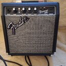 Kytarový kombo zesilovač značky Fender v černém provedení s kovovou mřížkou reproduktoru. Na ovládacím panelu jsou nápisy INPUT, GAIN, VOLUME, TREBLE…