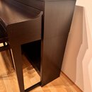 Tmavě hnědý digitální piano v dřevěném provedení. Na horní části je viditelné logo YAMAHA. Povrch nástroje vypadá hladce a bez výrazného opotřebení.