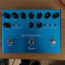 Modrý kytarový efekt s nápisem REFLECTING POOL a logem Fender. Zařízení má tři spínací tlačítka označená jako REVERB, TAP a DELAY. Na pravé straně se…