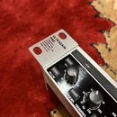 Detailní záběr na horní část stříbrného mikrofonního předzesilovače s černým předním panelem. Na horní kovové části je nápis ULTRAGAIN PRO AUDIOPHILE…