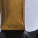 Detail zadní strany hředu kytary v přirozené dřevěné barvě s lakovaným povrchem. Na spodní části je černý nápis SERIAL NUMBER R 009002 a pod ním Craf…