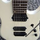 Bílá elektrická kytara s tmavým hmatníkem a bílými tečkovými značkami poloh. Nástroj má dva černý humbuckery a černý most s páčkou. Na těle jsou vidě…