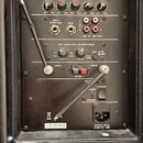 Černý ovládací panel reproduktoru s digitálním displejem a ovládacími prvky. Jsou zde nápisy SD/MMC, USB, MP3/WMA PLAYER a VOLUME, BASS, TREBLE, ECHO…
